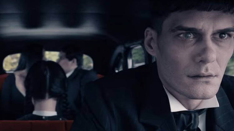 Lurch driving the car with Wednesday in the back.