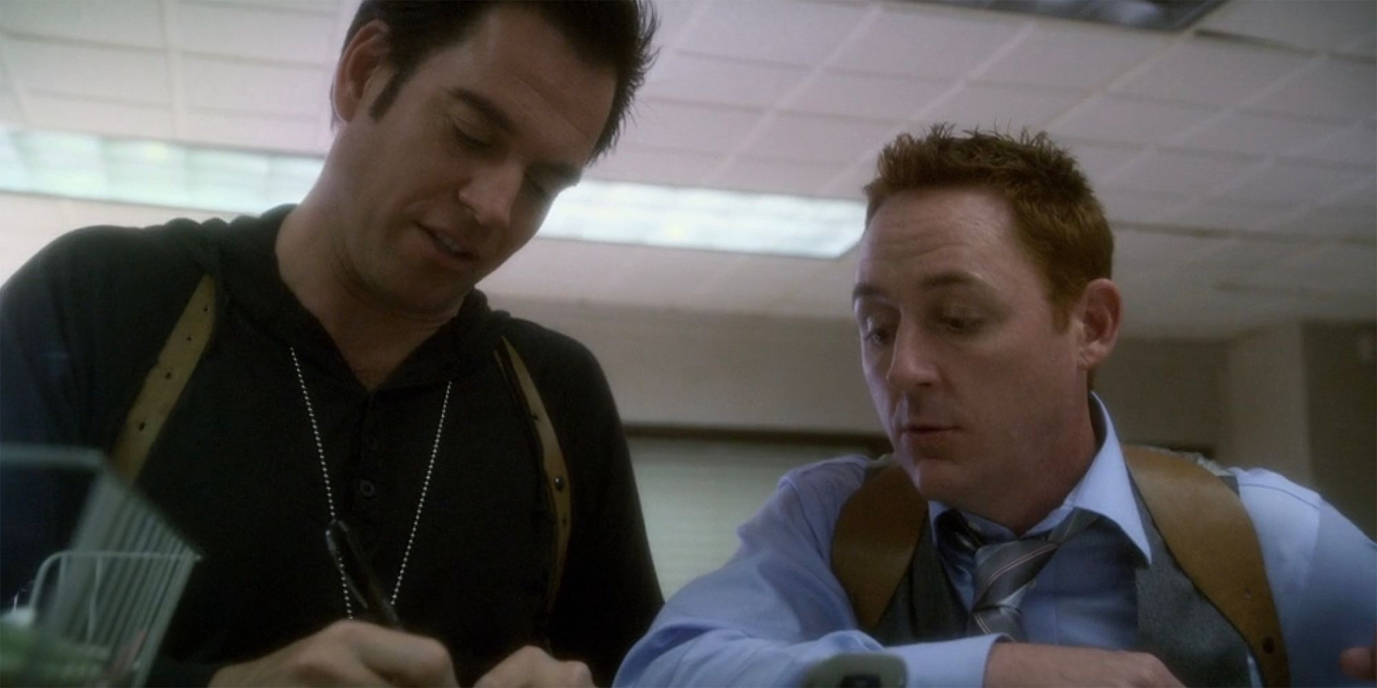 Tony and his partner looking at a cellphone in NCIS