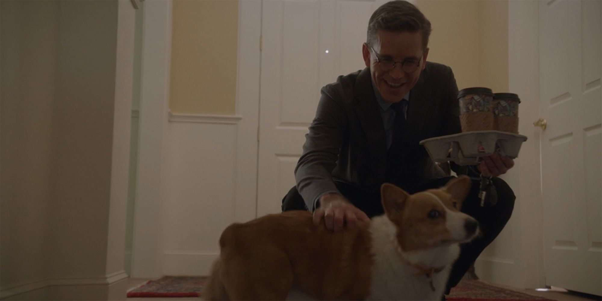 Jimmy Palmer bends over to pet dog while holding coffee in NCIS