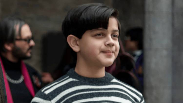 Pugsley Addams looking at something in Wednesday.