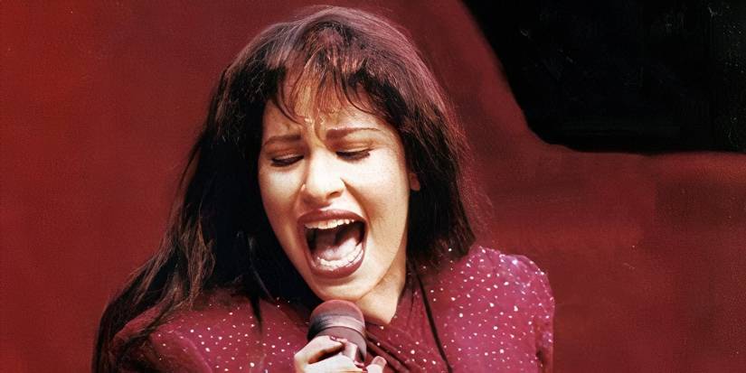 Selena wearing red and singing on stage.