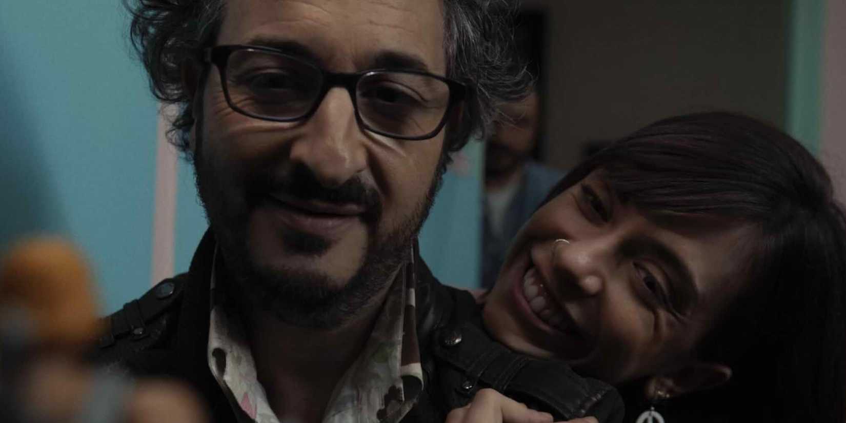 The Coffee Table couple looking happy, with a woman leaning her head on a man's shoulder 