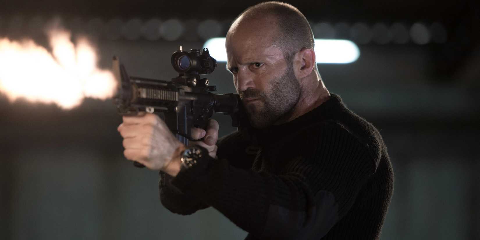 Jason Statham firing a machine gun as Arthur Bishop in The Mechanic