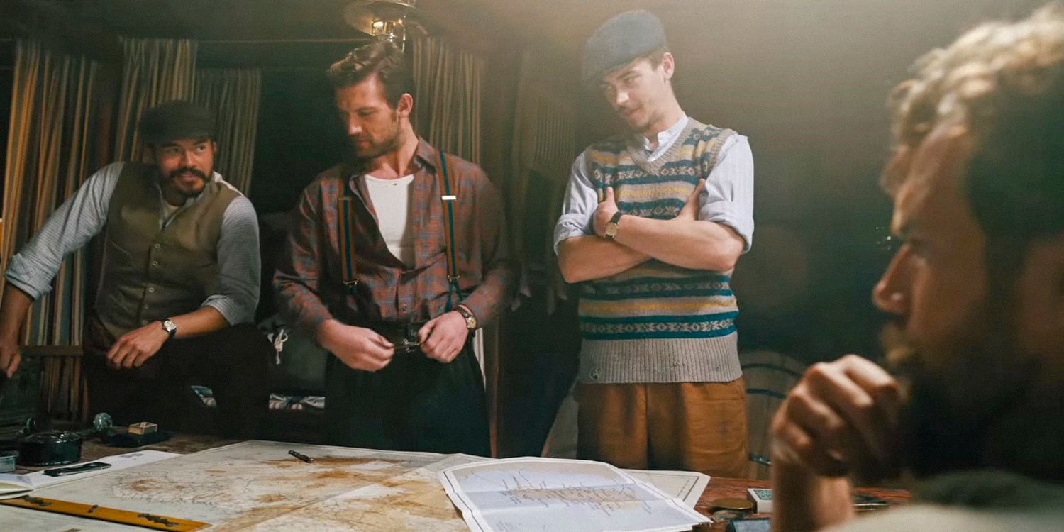 Freddy Alvarez (Henry Golding), Geoffrey Appleyard (Alex Pettyfer), Henry Hayes (Hero Fiennes Tiffin), and Gus March-Phillips (Henry Cavill) reviewing a map and planning a strategy in The Ministry of Ungentlemanly Warfare