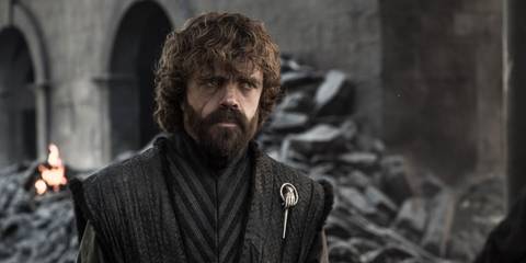 Peter Dinklage as Tyrion Lannister standing in the rubble of a ruined castle in Game of Thrones season 8