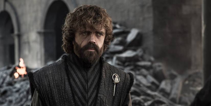 Peter Dinklage as Tyrion Lannister standing in the rubble of a ruined castle in Game of Thrones season 8
