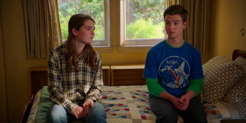Missy (Raegan Revord) and Sheldon (Iain Armitage) sitting on the edge of the bed with puzzled expressions in Young Sheldon season 7 episode 14 (FINALE)
