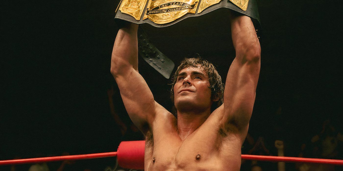 Zac Efron as Kevin Von Erich holding up the belt in The Iron Claw