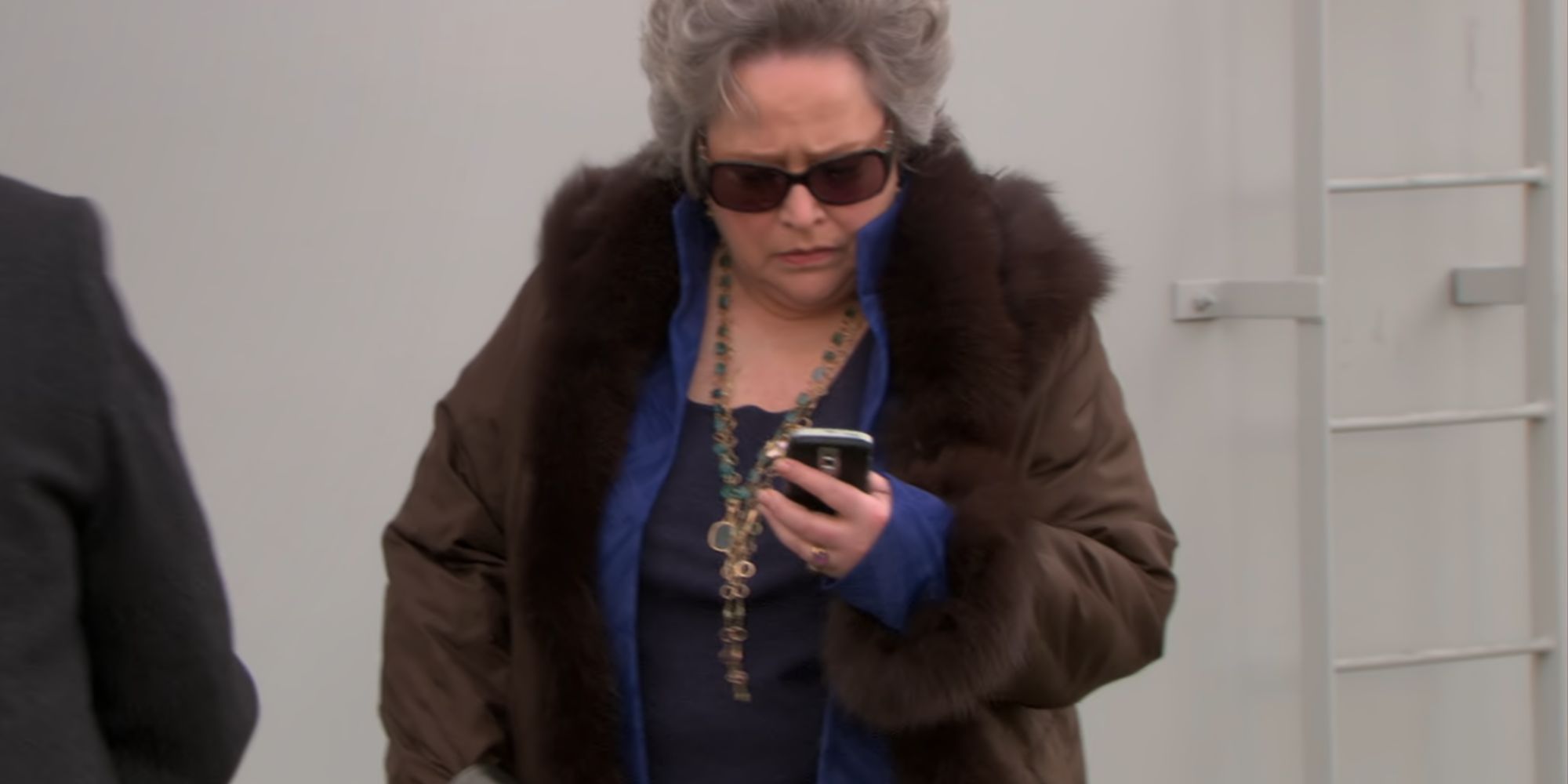 Kathy Bates looking at her phone as Jo Bennett in The Office