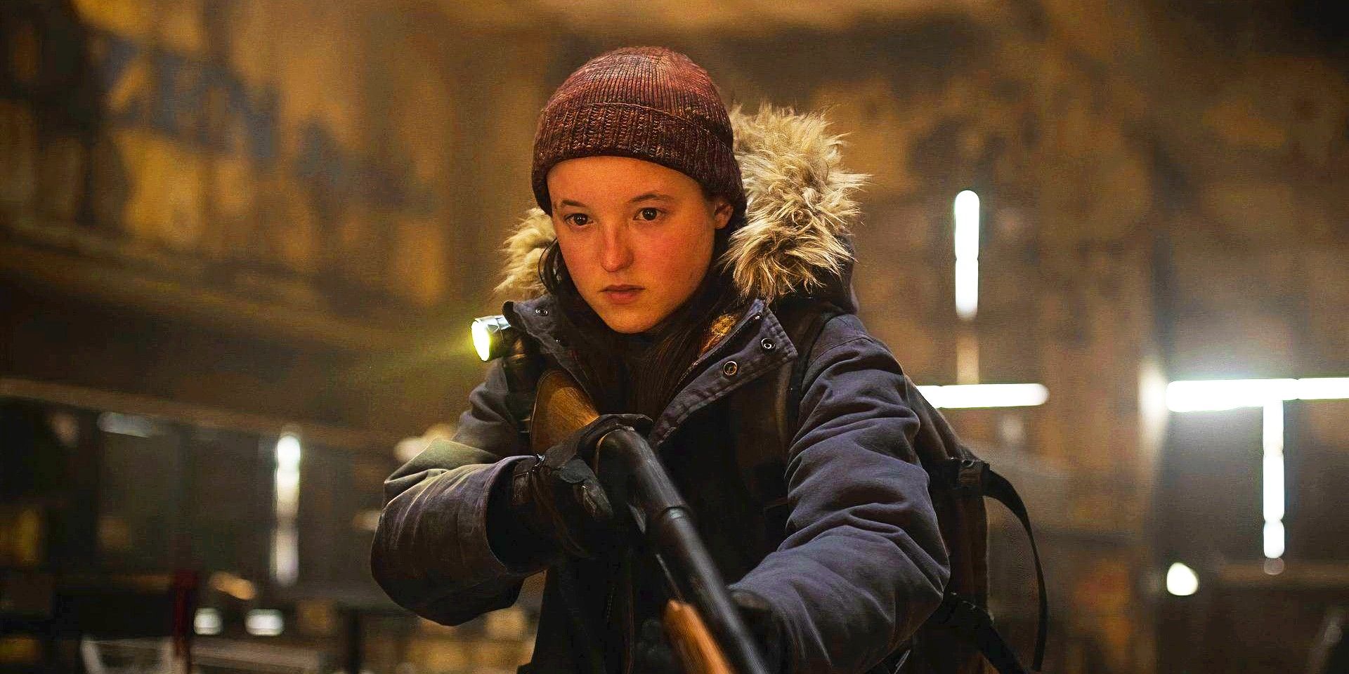 Bella Ramsey as Ellie wearing winter clothes and holding a shotgun in The Last of Us season 2.