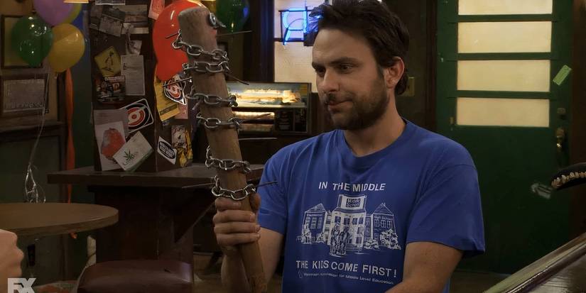 Charlie holding a plank with a chain around it in It's Always Sunny in Philadelphia
