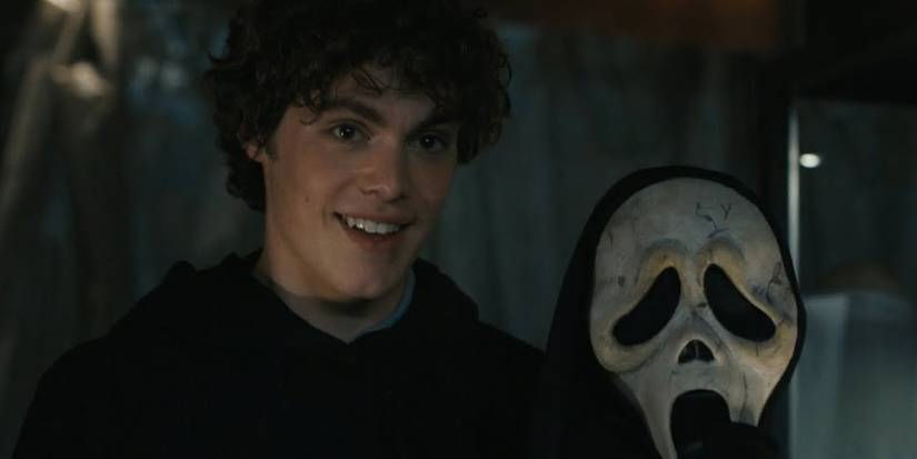 Ethan (Jack Champion) sorrindo com uma máscara Ghostface em Scream