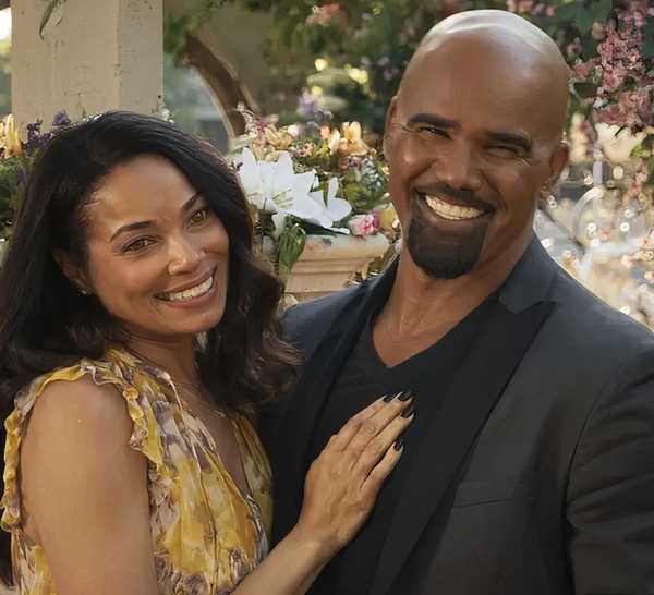 Hondo and Nichelle dressed up and standing outside, with her hand on his chest, in a scene from SWAT
