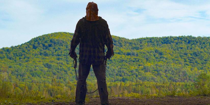 A masked killer  looks out over a cliff from In a Violent Nature 2024