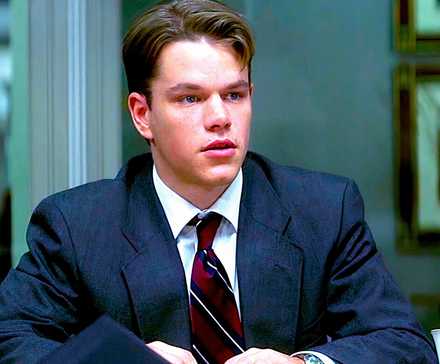 Мэтт Дэймон в костюме, сидящий и выглядящий обеспокоенным в сцене из "The Rainmaker"