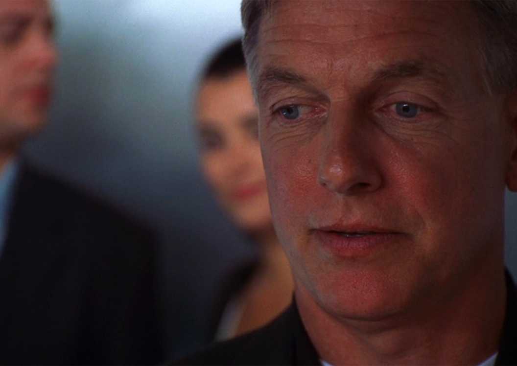 A close up of Mark Harmon as Jethro Gibbs with McGee (Sean Murray) and Ziva (Cote de Pablo) behind him in the NCIS elevator