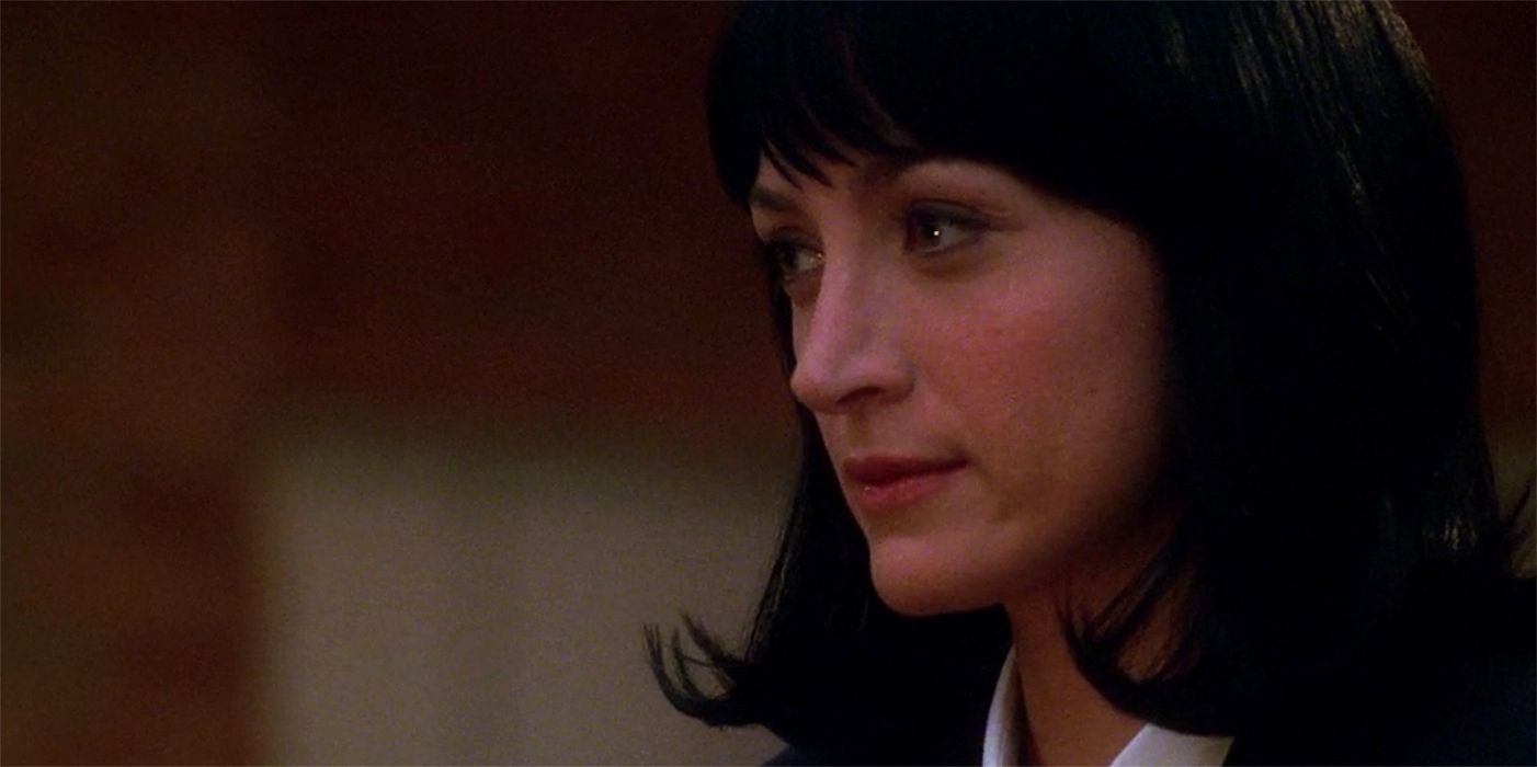 A close up of Kate Todd wearing a black wig from the side