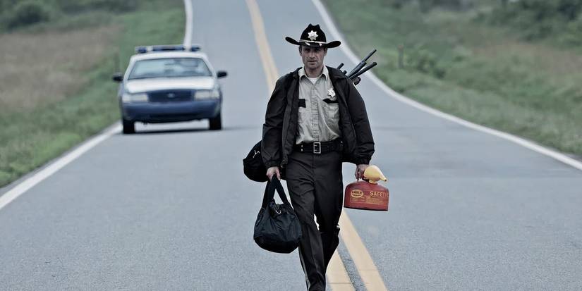 Andrew Lincoln as Rick Grimes walking with supplies in The Walking Dead, Days Gone Bye