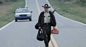 Andrew Lincoln as Rick Grimes walking with supplies in The Walking Dead, Days Gone Bye
