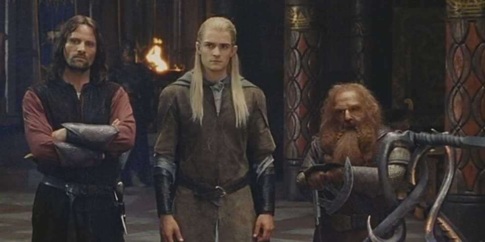 Gimli, Legolas and Aragorn standing in a row in The Lord of the Rings: The Two Towers.
