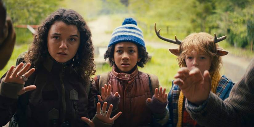 Bear (Stefania LaVie Owen), Wendy (Naledi Murray) und Gus (Christian Convery) heben in Staffel 3 von Sweet Tooth die Hände, als sie mit einer Waffe auf sie zielen