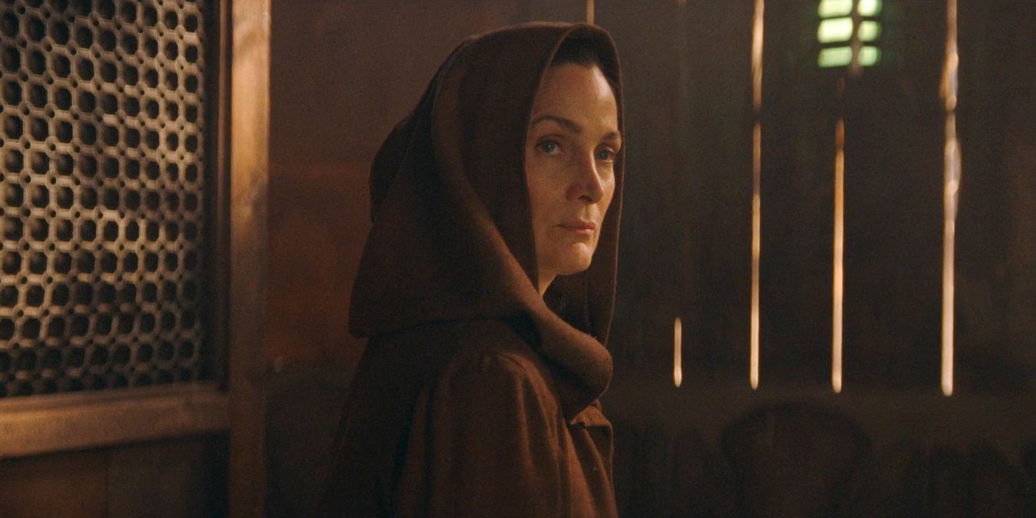 Indara (Carrie-Anne Moss) wearing a robe looking over her shoulder in The Acolyte Season 1, episode 1