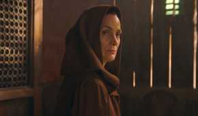 Indara (Carrie-Anne Moss) wearing a robe looking over her shoulder in The Acolyte Season 1, episode 1