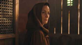 Indara (Carrie-Anne Moss) wearing a robe looking over her shoulder in The Acolyte Season 1, episode 1