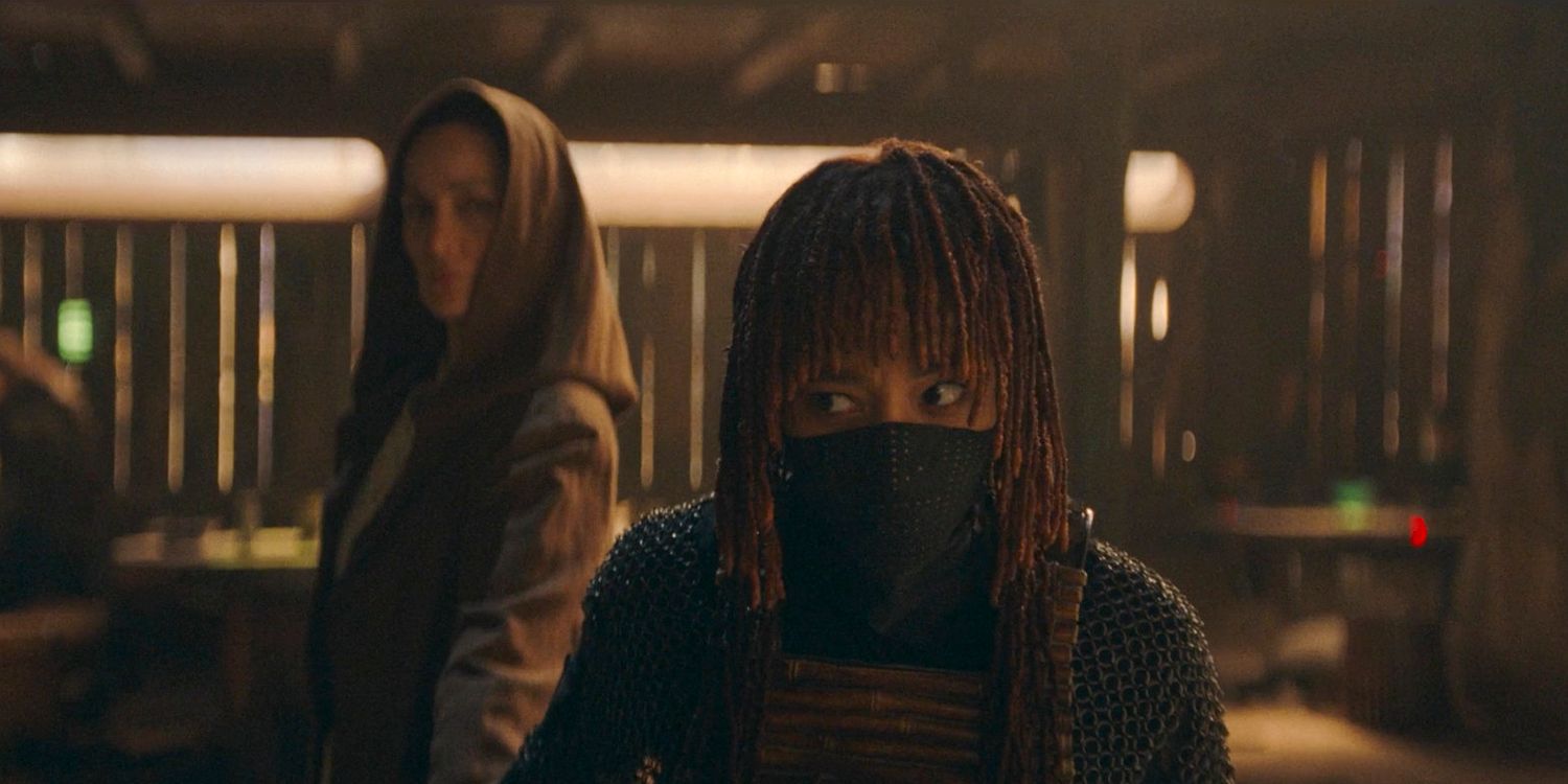 Mae (Amandla Stenberg) glancing sideways at Indara (Carrie-Anne Moss) who is behind her in The Acolyte Season 1, episode 1