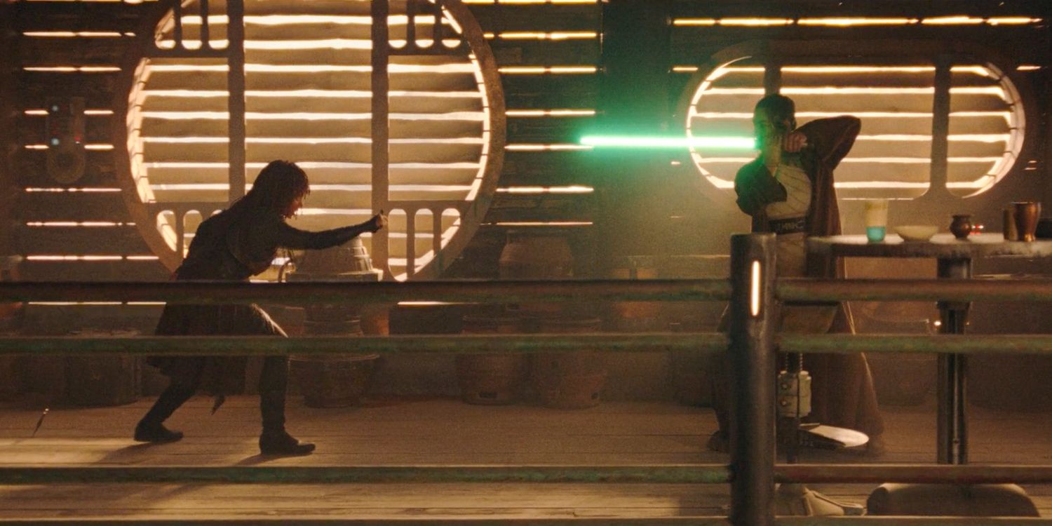 Mae (Amandla Stenberg) and Indara (Carrie-Anne Moss) using her lightsaber, face off in a battle in The Acolyte Season 1, episode 1