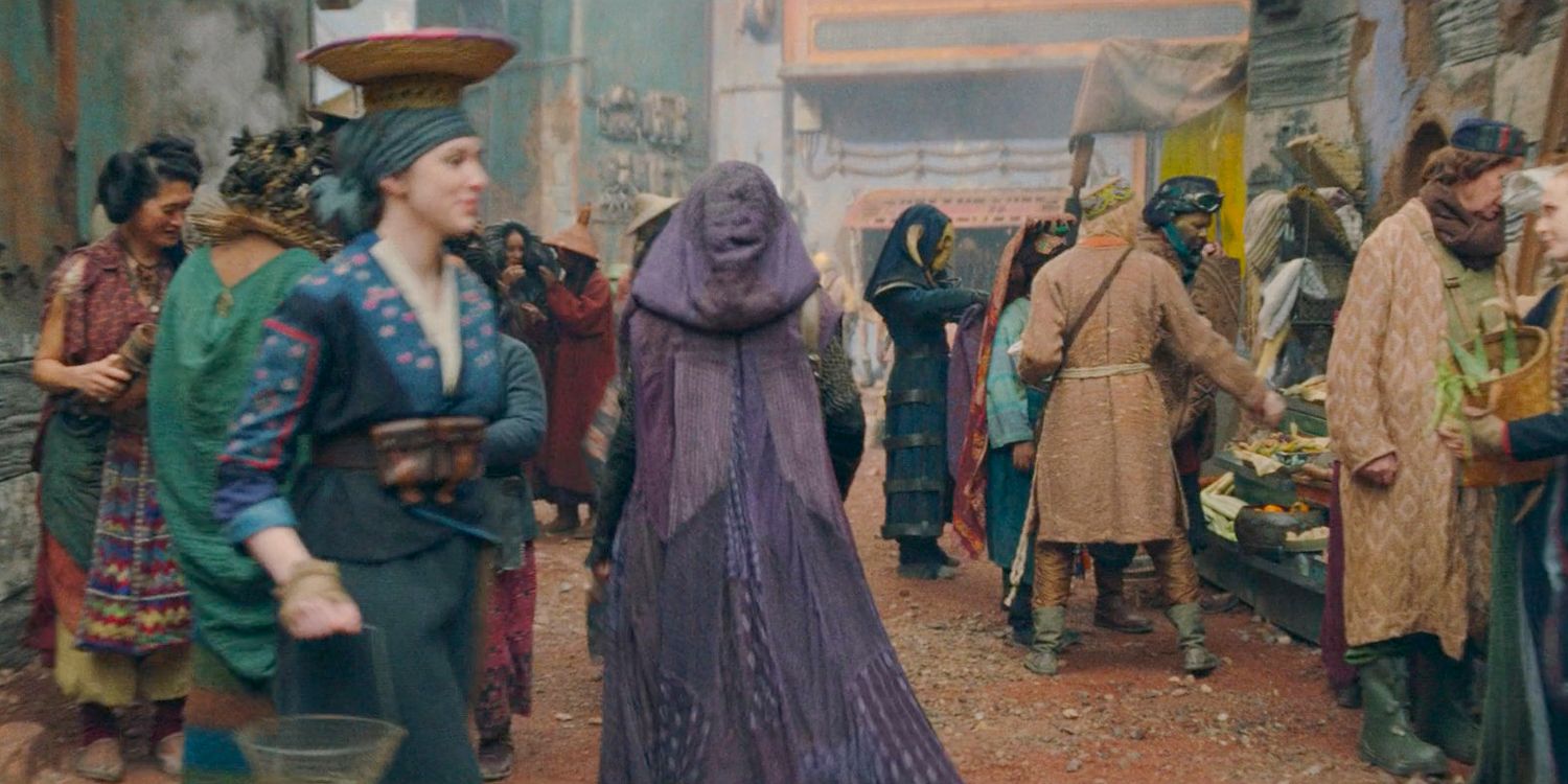 Mae wearing a purple cloak sneaking through the crowd in Olega in The Acolyte Season 1 episode 2