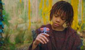 Little Osha (Lauren Brady) looking down at a creature on her hand in The Acolyte season 1 episode 3