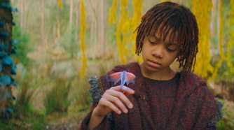 Little Osha (Lauren Brady) looking down at a creature on her hand in The Acolyte season 1 episode 3