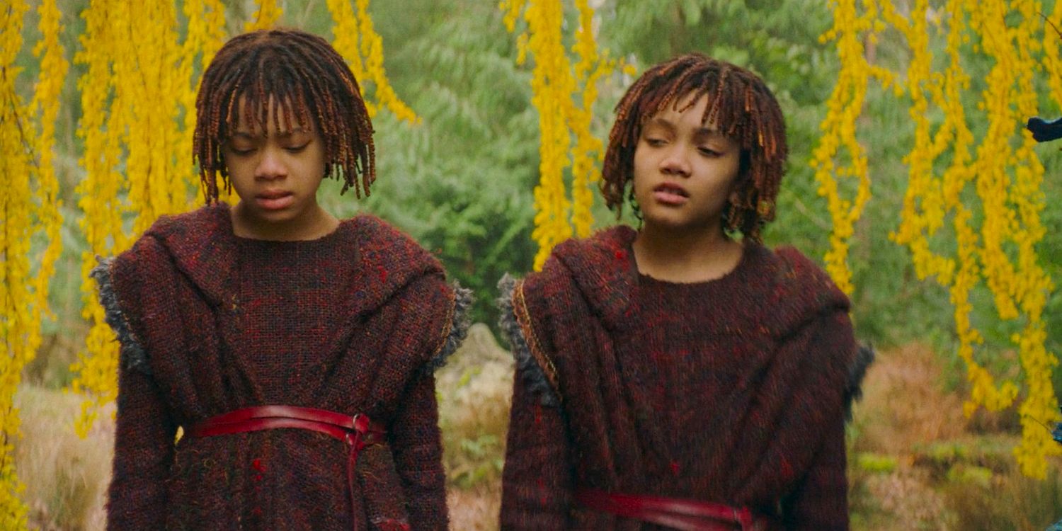 Little Mae (Leah Brady) and Little Osha (Lauren Brady) looking upset side-by-side under the bunta tree in The Acolyte season 1 episode 3