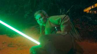 Jecki Lon (Dafne Keen) holding her lightsaber while lying on the ground in The Acolyte season 1 episode 5