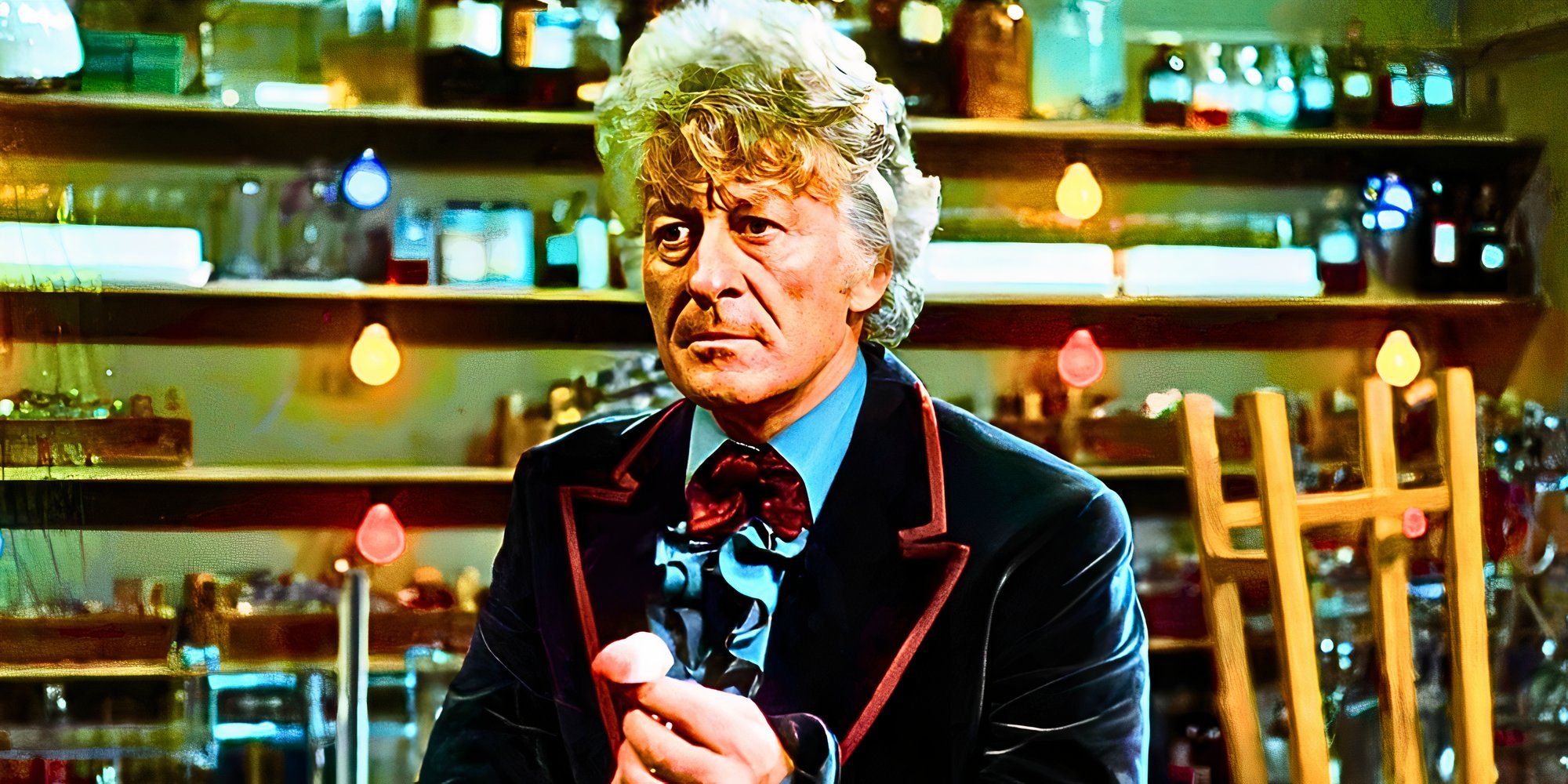 Jon Pertwee as the Third Doctor holding something and looking serious in Doctor Who.