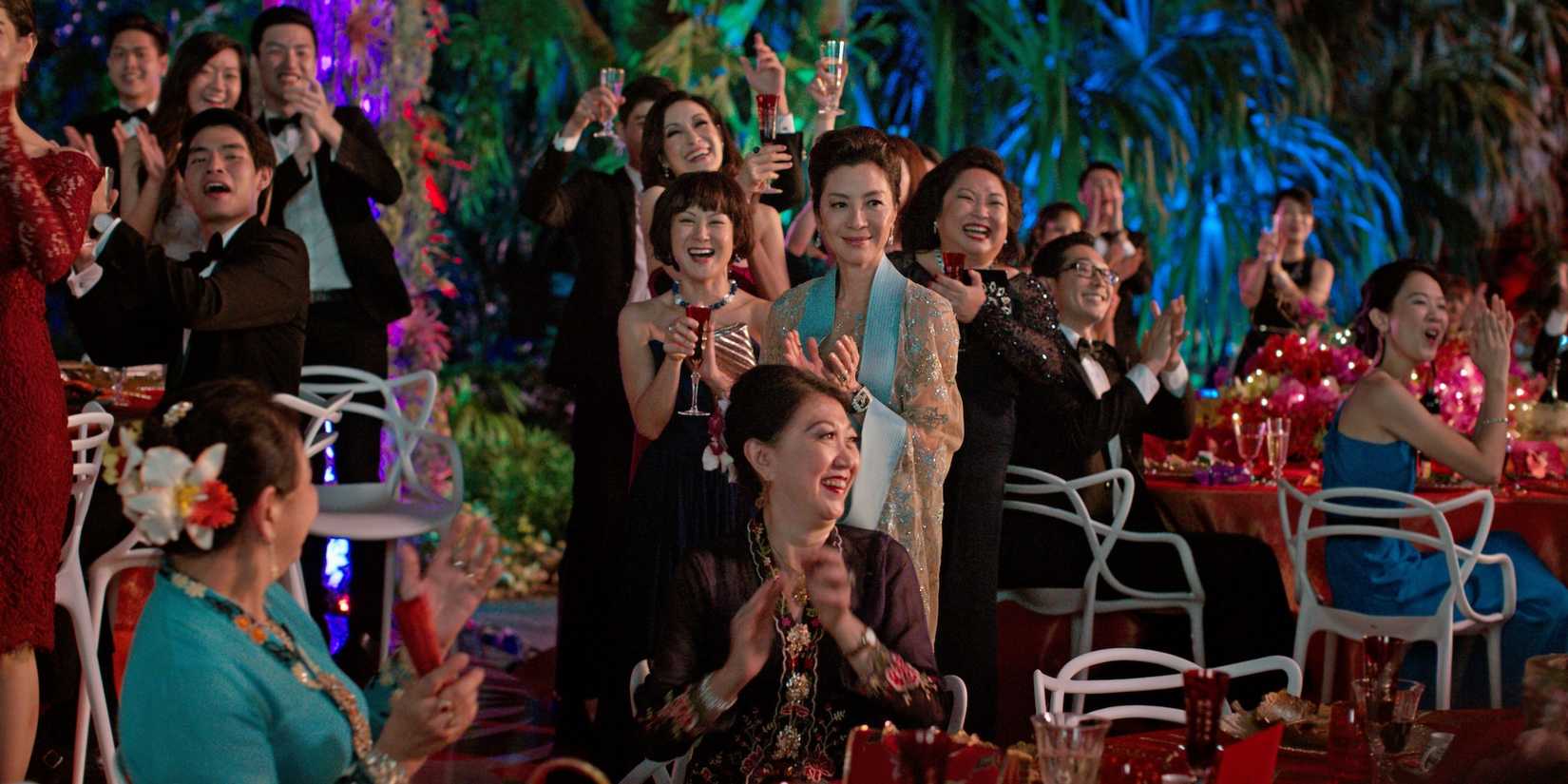 A crowd claps at a Wedding reception in Crazy Rich Asians