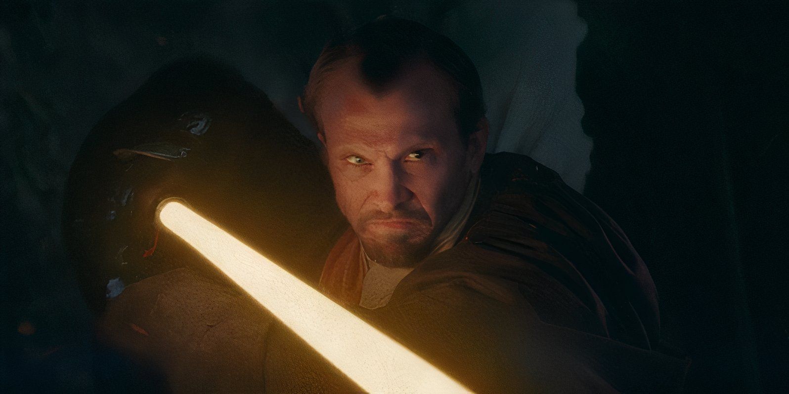 An unidentified Jedi snarls with his face lit up by his yellow lightsaber in The Acolyte episode 5