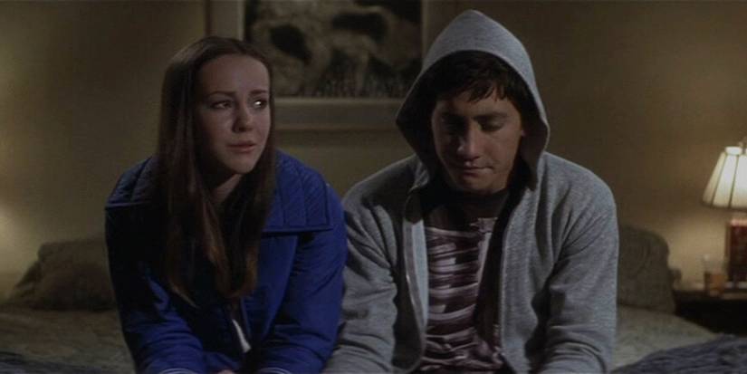 At a Halloween house party at the Darko residence, Donnie and Gretchen sit on the bed in his parents' bedroom having an emotional conversation.