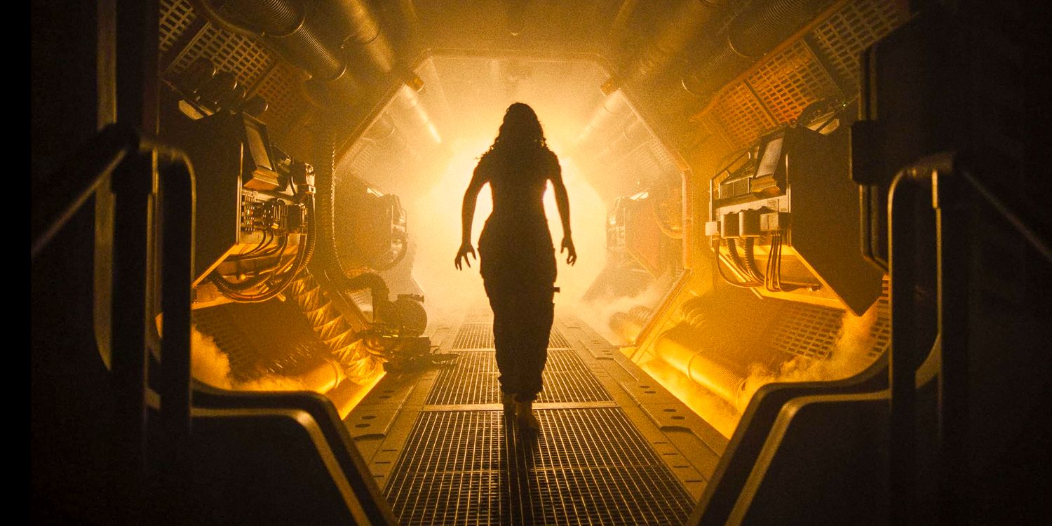 The silhouette of Rain Carradine walking down the hallway of a spaceship illuminated with yellow light in Alien: Romulus