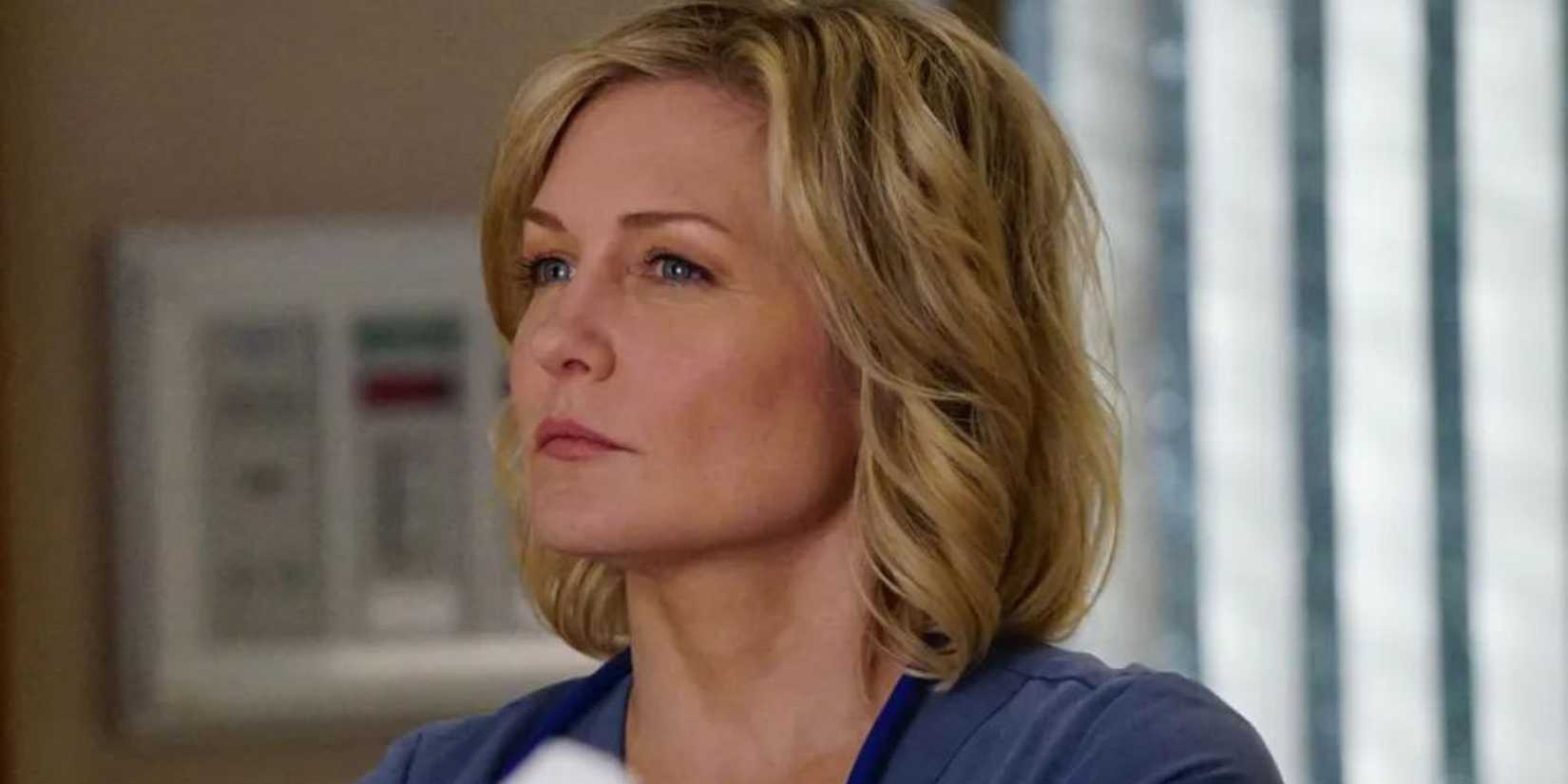 Amy Carlson as Linda Reagan on Blue Bloods, standing in front of a window with a determined look