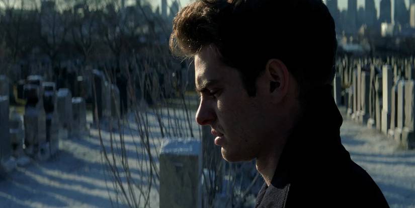 Andrew Garfield as Peter Parker standing at a grave in the Amazing Spider-Man 2