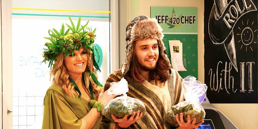Dougie Baldwin's Pete stands in the store holding two big bags of cannabis as a woman stands by his side in Disjointed