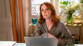 Sylvie (Philippine Leroy-Beaulieu) looking thoughtful in front of her laptop in Emily in Paris season 4
