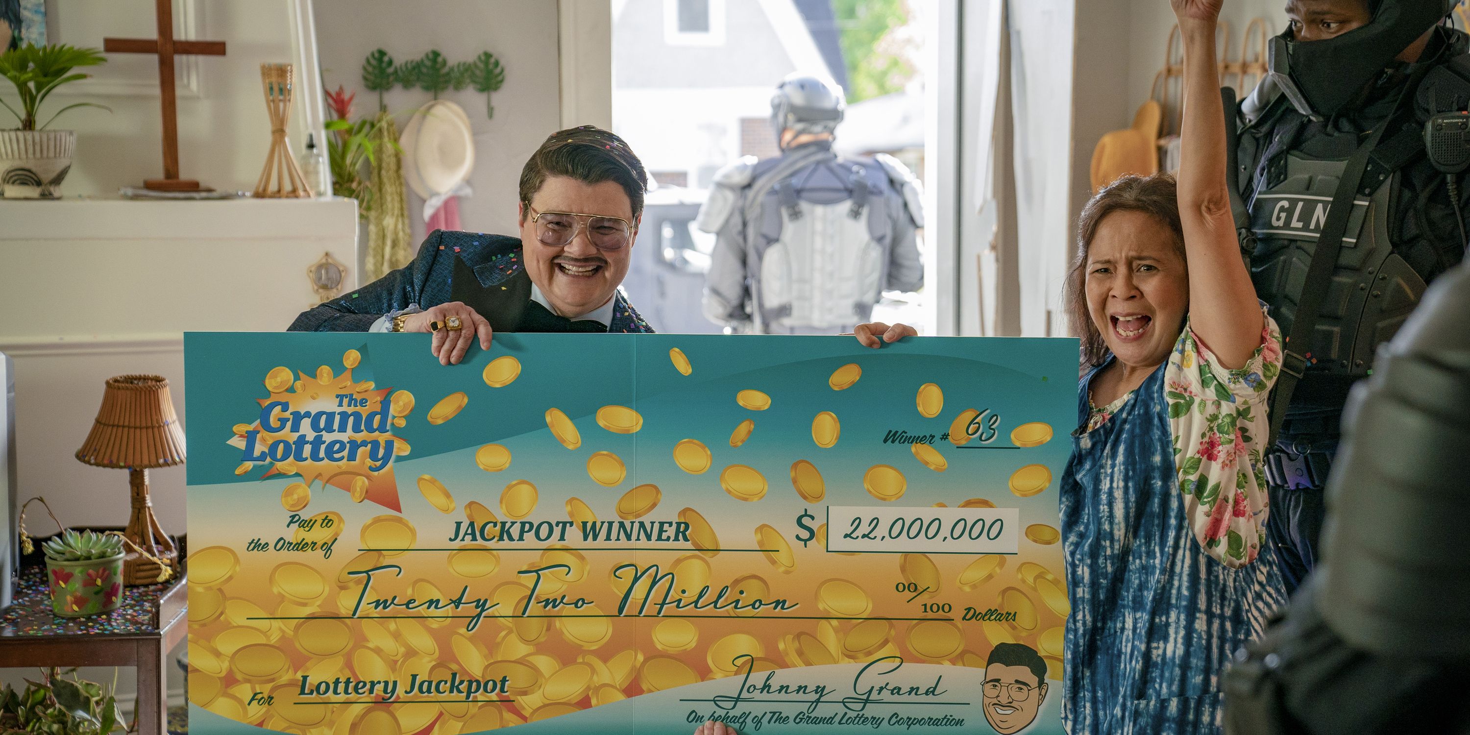 Johnny Grand (Murray Hill) and Tala (Dolly De Leon) holding a giant check in Jackpot.
