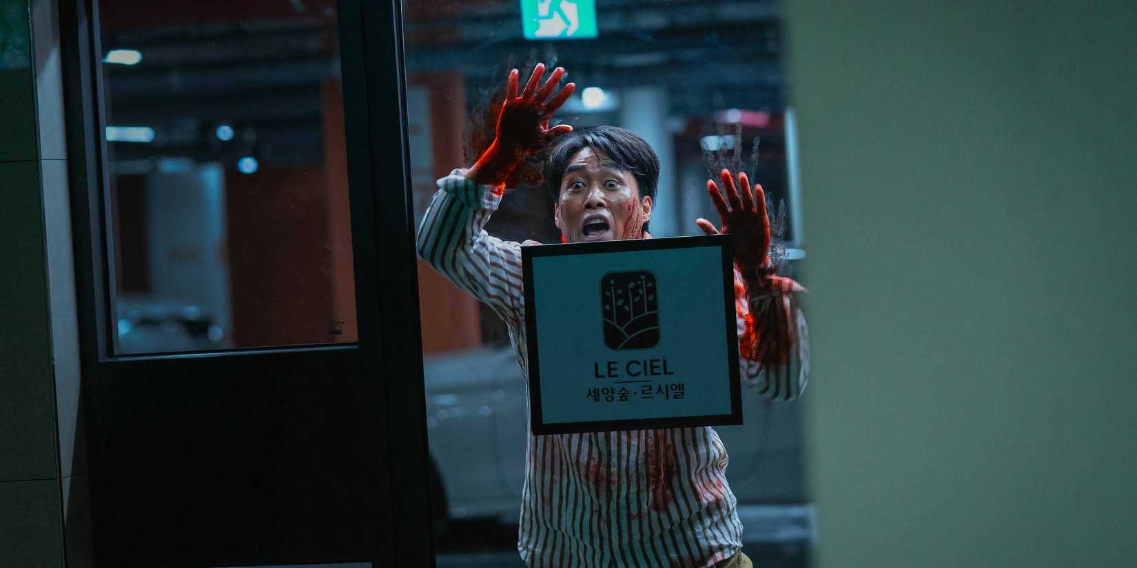 A man covered in blood bangs against a door in Happiness.