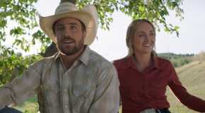 Nathan and Amy sit under a tree together in Heartland
