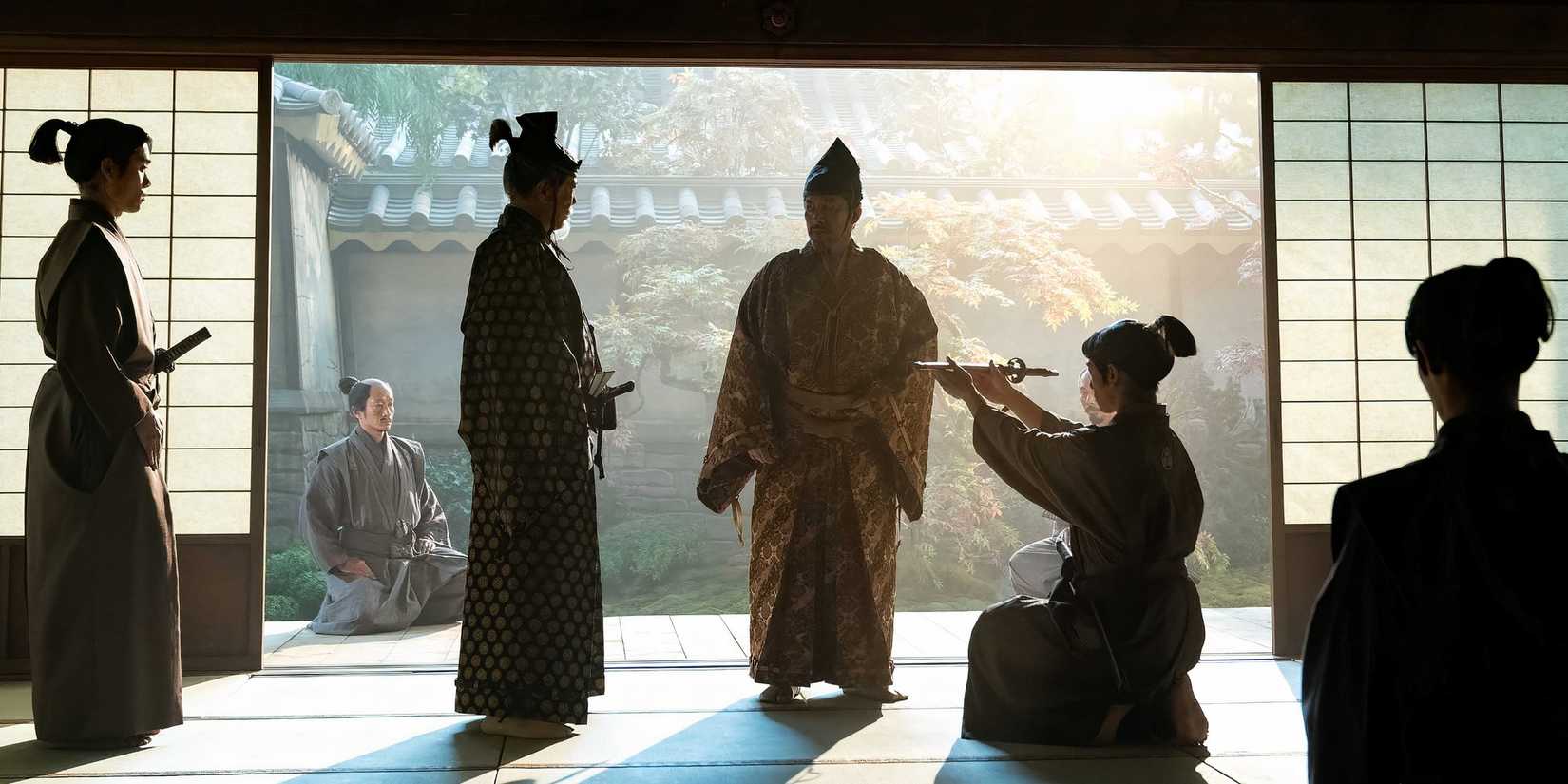 Man kneeling and presenting a sword in Shogun
