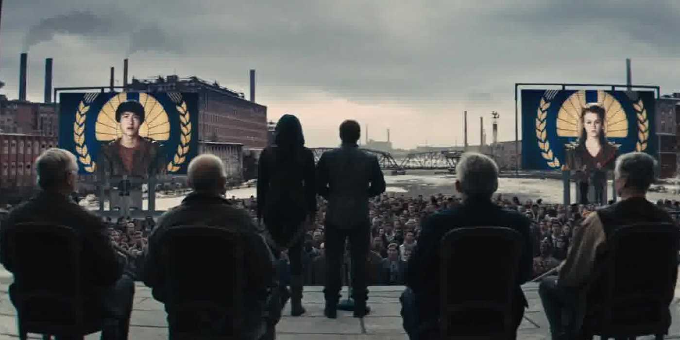 katniss and peeta standing in front of the district 8s people