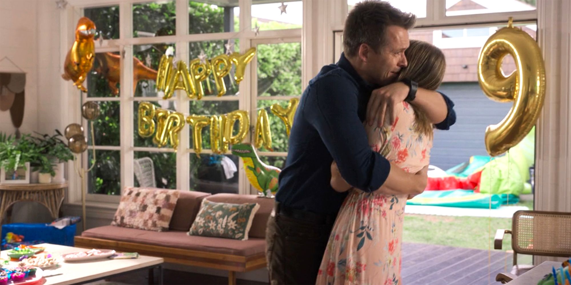 JD cluthes his ex-wife in despair in front of happy birthday balloons in NCIS Sydney